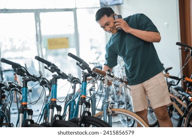 young man on the phone checking out some new bikes at a bike shop - Powered by Shutterstock