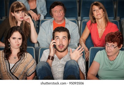 Young man on phone disturbs people in theater - Powered by Shutterstock