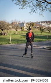 Young Man On Roller Blade Looking  At His Phone. Technologie In Nature.