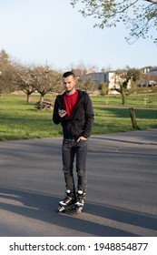 Young Man On Roller Blade Looking  At His Phone. Technologie In Nature.