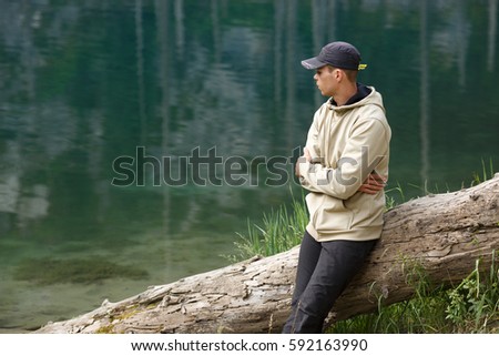 Similar – Man sitting by the river in fall