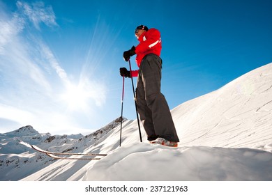 Young man on top of a mountain ready for skiing