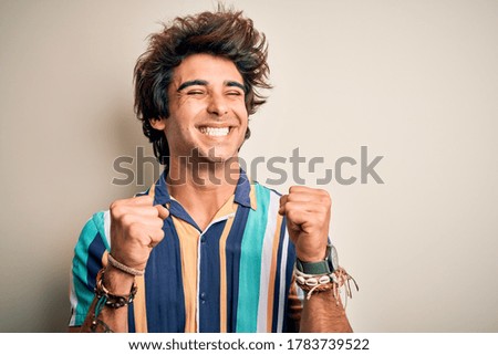 Young man on vacation wearing summer colorful shirt standing over isolated white background excited for success with arms raised and eyes closed celebrating victory smiling. Winner concept.