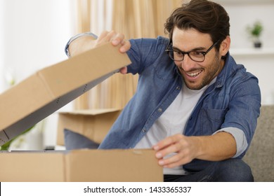 Young Man Opening A Box