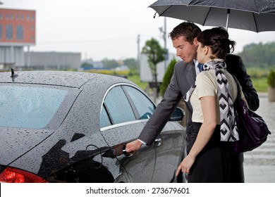 Young Man Opening Door Of Car For Woman