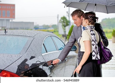 Young Man Opening Door Of Car For Woman