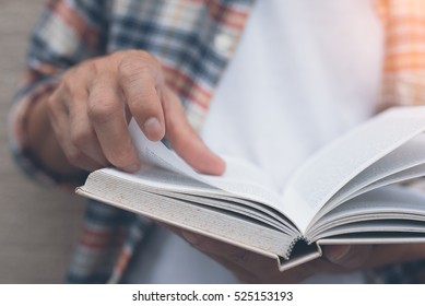 Young man opening and reading a book, close up, vintage style. - Powered by Shutterstock