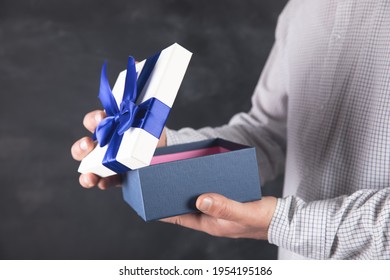 Young Man Opens A Fascinating Gift Box .