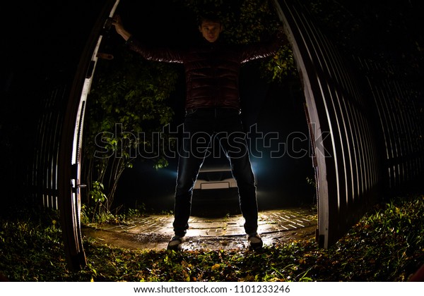 A young man\
opens the gate to drive out the\
car