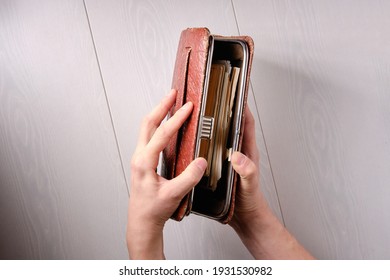 Young Man Opens A Vintage Vintage Clutch Bag With Documents, Top View