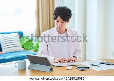 Young man operating a computer in his room