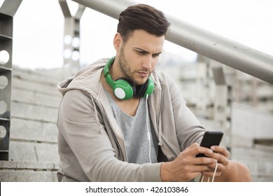 Young Man Outdoors Texting And Looking Worried