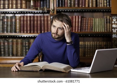 A Young Man Over A Book With Laptop In Classic Library