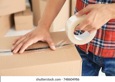Young man packing box, indoors