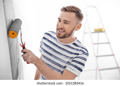 Young Man Painting Wall In Room