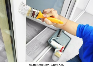 Young Man Painting Window At Home, Closeup