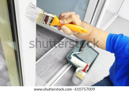 Young man painting window at home, closeup