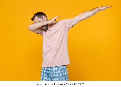 Young Man In Pajamas Home Wear Doing Dab Hip Hop Dance Hands Gesture, Youth Sign Hiding Covering Face Resting At Home Isolated On Yellow Background Studio Portrait. Relax Good Mood Lifestyle Concept