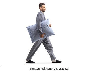 Young Man In Pajamas Walking And Carrying A Pillow Isolated On White Background