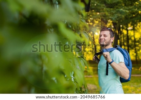 A young man in the park with a backpack