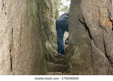 young man passing through between stones