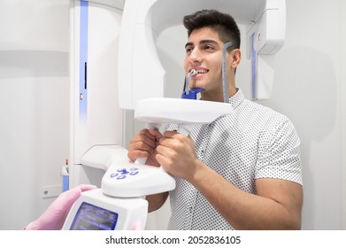 Young Man Patient Standing In X-ray Machine. Panoramic Radiography. High Quality Photo.