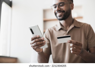 Young Man Paying Online With Credit Card And Smartphone At Home. Online Shopping, E-commerce, Internet Banking, Spending Money Concept