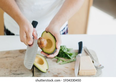 Young man peeling avocado and making healthy toasts in modern white kitchen. Perfectly ripe avocado in hands. Healthy eating and Home cooking concept - Powered by Shutterstock