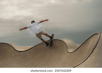 Young man performing a skateboard trick at a beachfront skate pa - Powered by Shutterstock