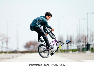 Young man performing tricks with a flatland bmx bike