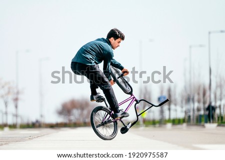 Young man performing tricks with a flatland bmx bike
