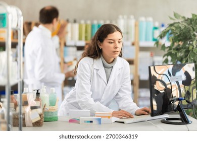 Young man pharmacist working with computer in pharmacy