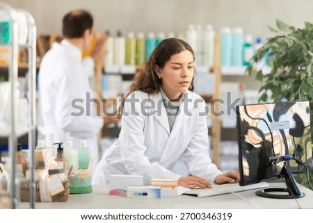 Young man pharmacist working with computer in pharmacy