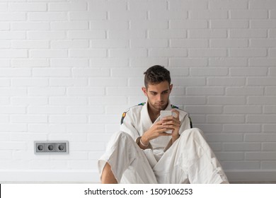 young man with phone in martial arts gym - Powered by Shutterstock