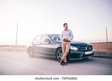 Young Man Phone Poses With His Car.