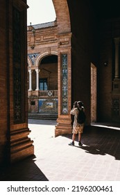 Young Man Photographing The Plaza De España (Spain Square) Underneath An Arch In Seville, Andalusia. Travel Concept