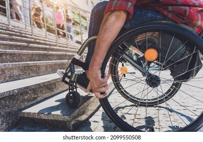 Young Man With A Physical Disability Who Uses Wheelchair In Front Of The Stairs