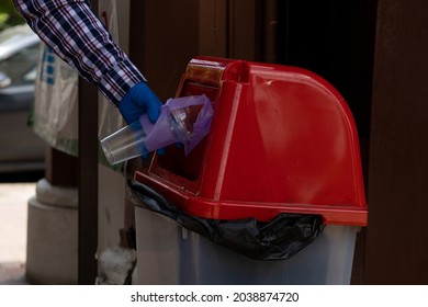 Young Man Picking Up Trash Bottles Plastic In The Park To Clean The Environment