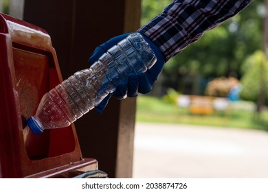 Young Man Picking Up Trash Bottles Plastic In The Park To Clean The Environment