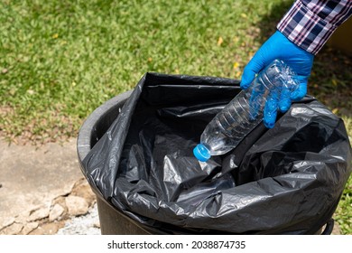 Young Man Picking Up Trash Bottles Plastic In The Park To Clean The Environment