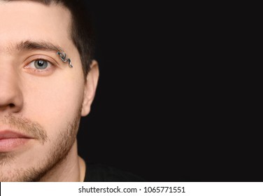 Young Man With Pierced Eyebrow On Black Background