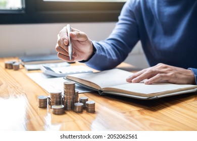 Young man and pile coins to planning growing saving strategy with pile coins for future plan fund of travel, education, home and retirement. - Shutterstock ID 2052062561