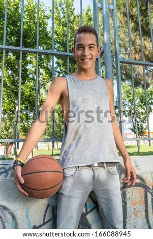 Similar – Teenage boy holding a basketball on a court