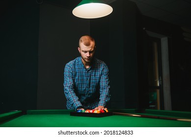 Young Man Playing Billiards In The Dark Billiard Club