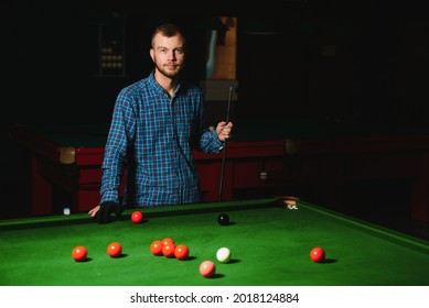 Young Man Playing Billiards In The Dark Billiard Club