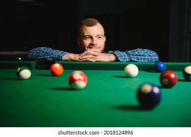 Young Man Playing Billiards In The Dark Billiard Club