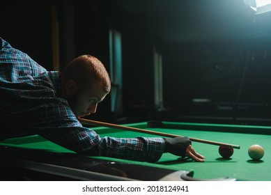 Young Man Playing Billiards In The Dark Billiard Club