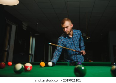 Young Man Playing Billiards In The Dark Billiard Club