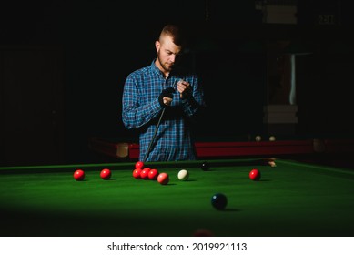 Young Man Playing Billiards In The Dark Billiard Club