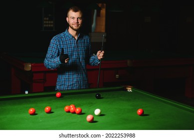 Young Man Playing Billiards In The Dark Billiard Club